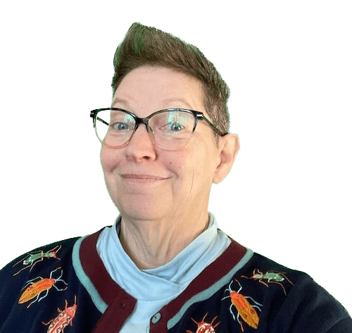 A photo of gwen pearson wearing a cool blue sweater with embroidered beetles. She is smiling and wearing glasses.
